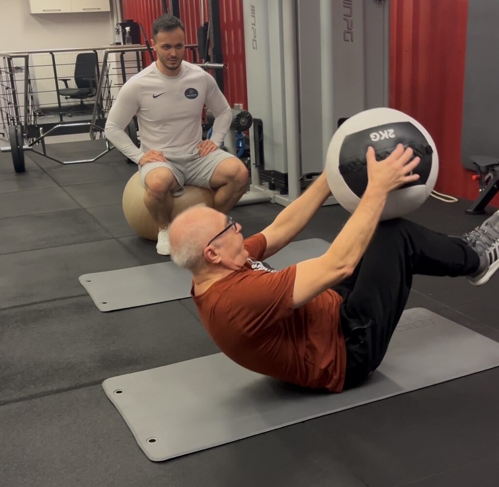Trener personalny Body Movement Mokotów kontroluje technikę ćwiczenia podczas treningu indywidualnego.